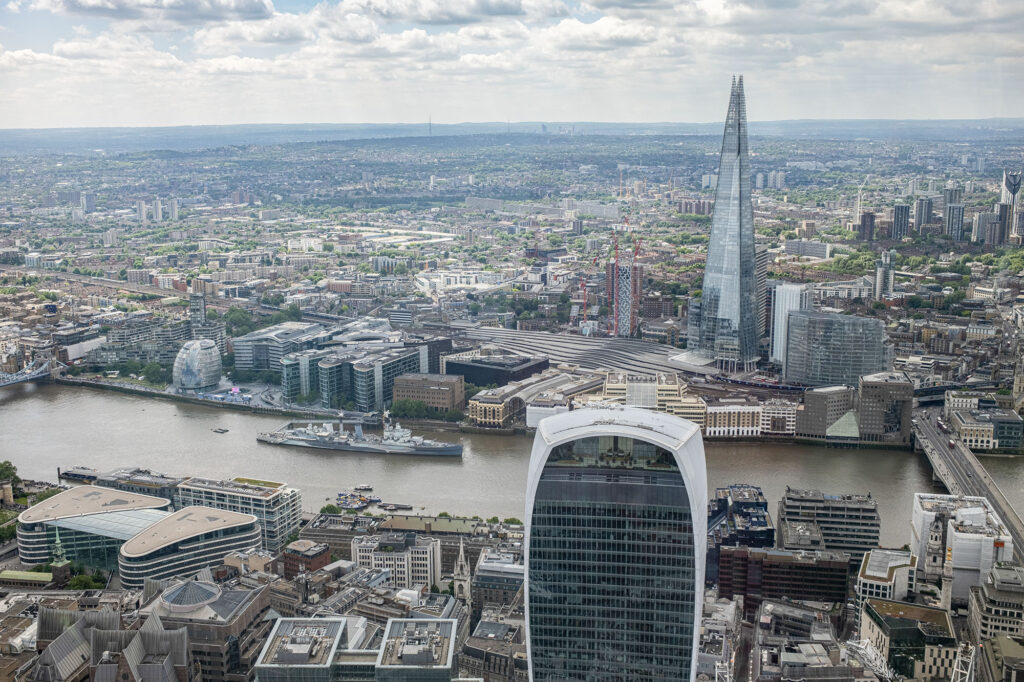 View looking South over the River Thames from Horizon 22, a free viewing platform in London. The Shard, Walkie Talkie and HMS Belfast can be seen.