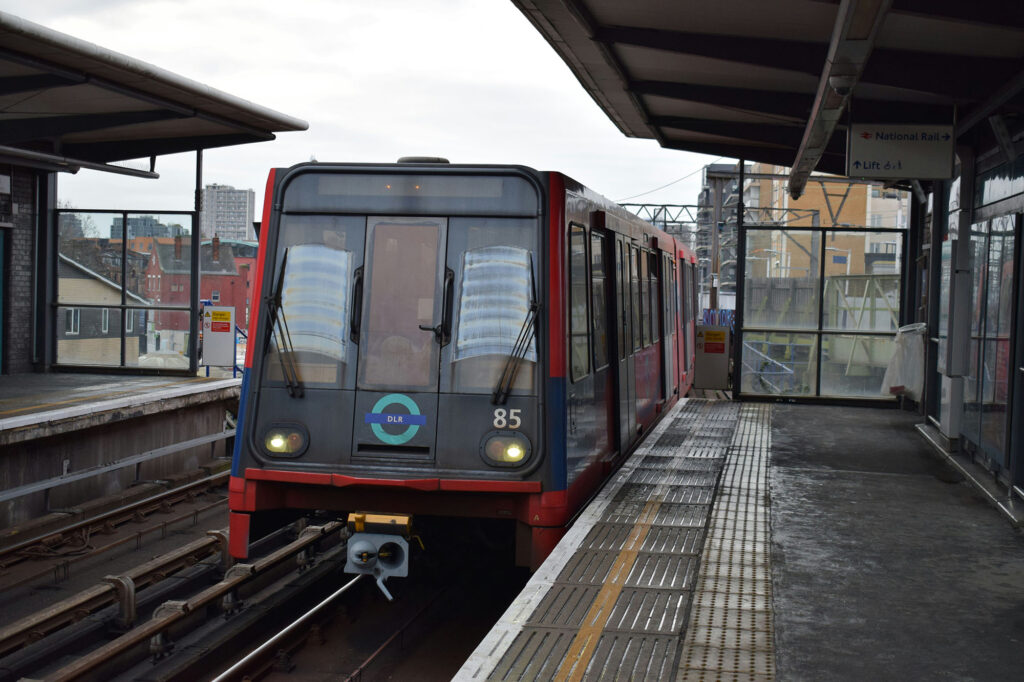 A photo of a Docklands Light Railway (DLR) train pulling into a station.