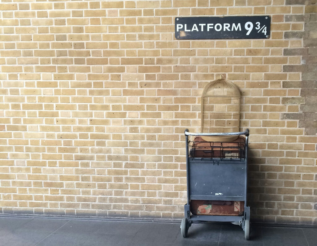 A picture of Platform 9 and three quarters at King's Cross Station with the trolley disappearing into the wall.