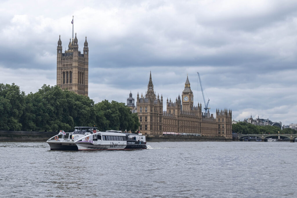 Photo of an Uber boat doing a cruise on the River Thames in front of the Houses of Parliament.