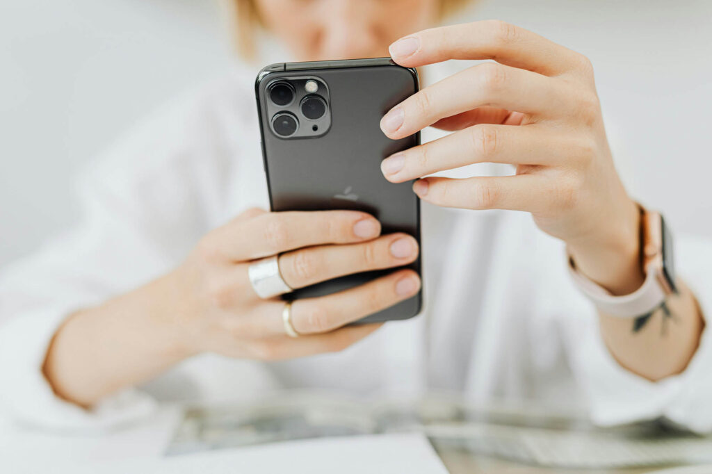 Photo of a woman holding a mobile phone with two hands